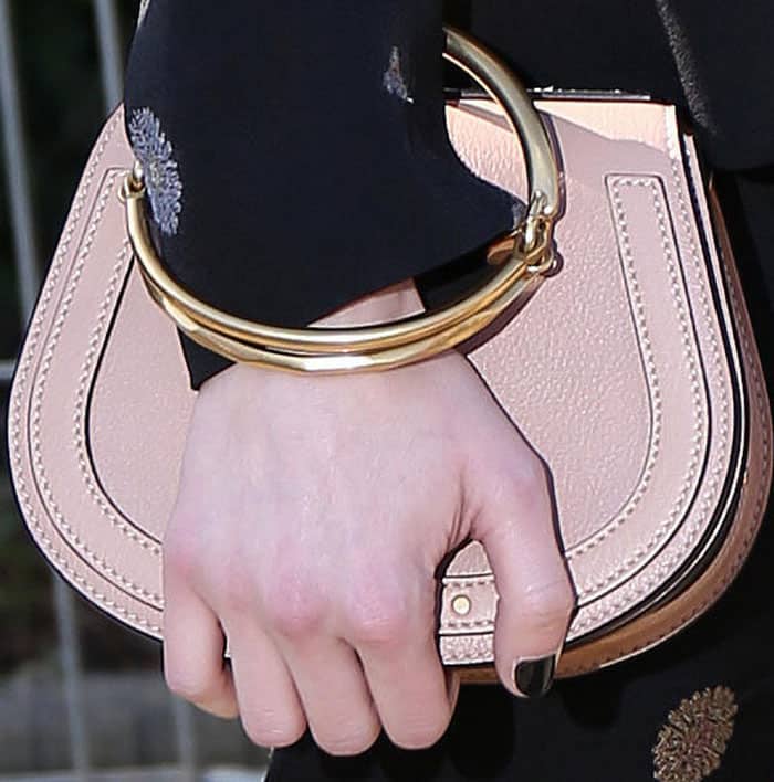Emma stylishly clutches her Chloé "Nile" bracelet bag